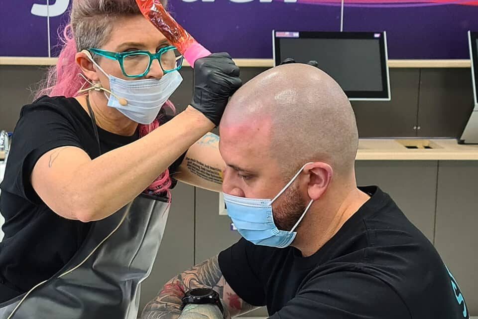 A Foli Sim artist applying scalp micropigmentation to a client